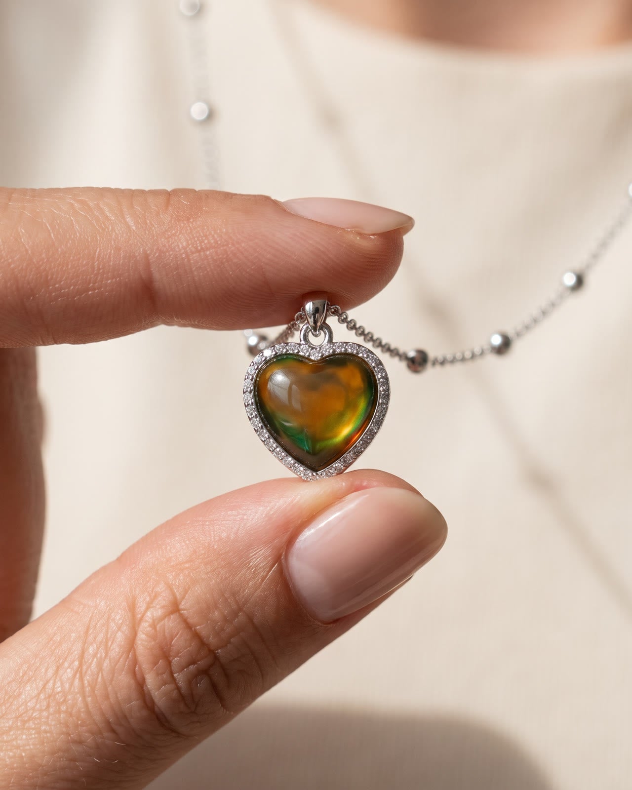 The Mood Heart held to the light as it shifts from amber to green